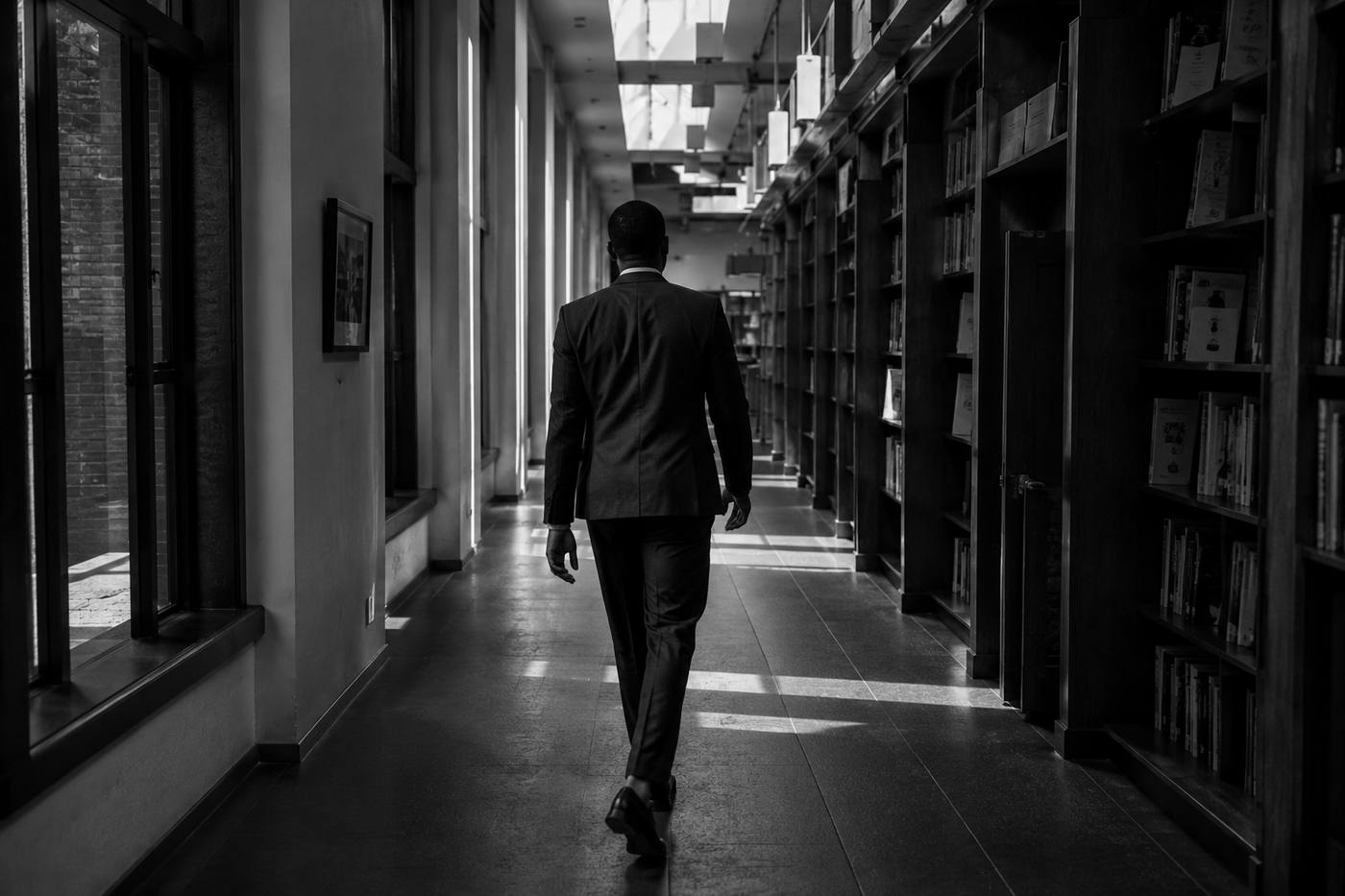 Leader walking forward through an office corridor